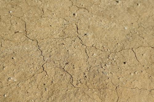 Dry and cracked soil is shown during drought.